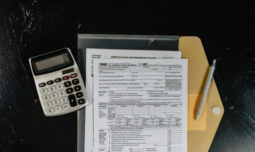 Tax forms and calculator on a dark surface